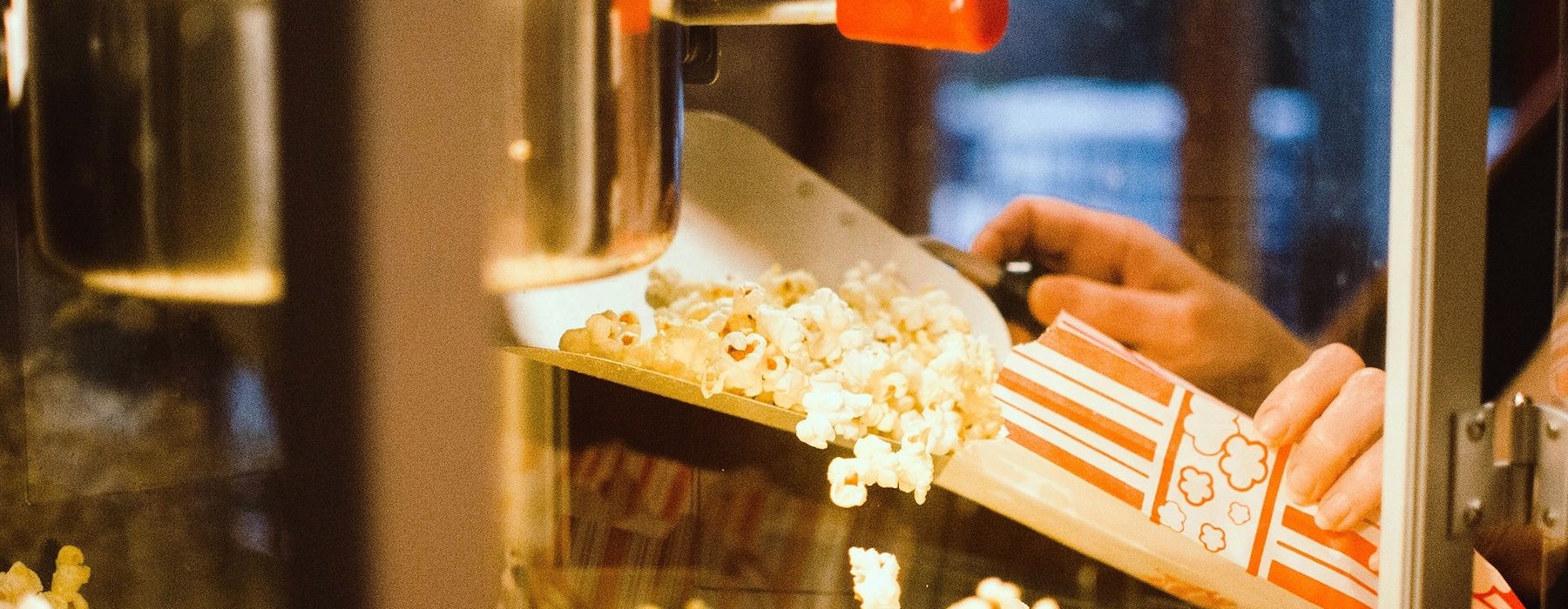 a person pouring popcorn into a container